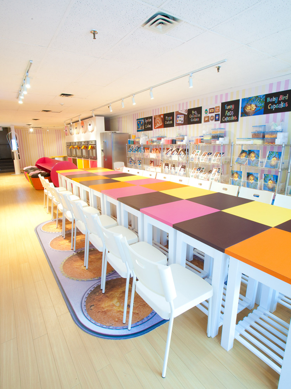 The colourful checked group table inside the bakeshop sits on top of a "muffin tin" mat.