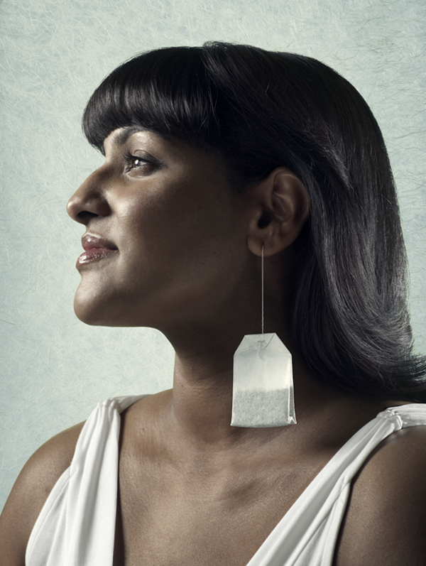 An elegant woman wears a teabag as an earring