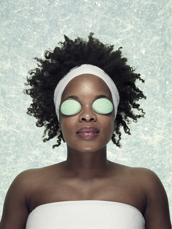 A woman in a spa setting has 2 dove cool moisture beauty bars on her eyes in place of cucumbers