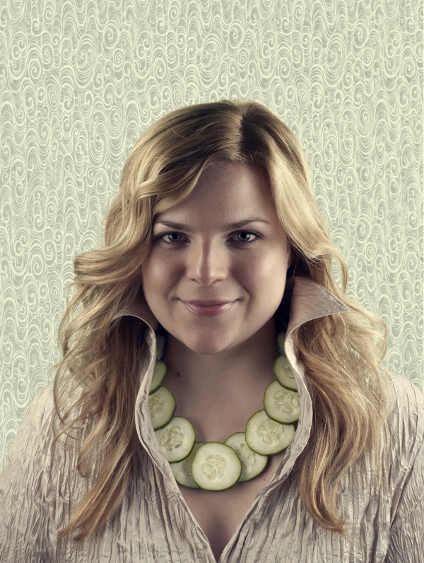 A woman wears a necklace made of cucumber slices